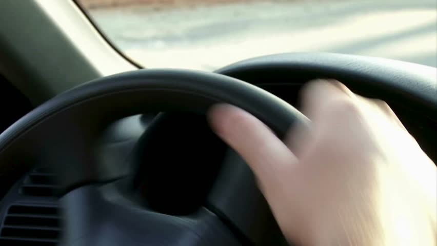 Closeup guy hand on car steering wheel. A man holds his car's steering wheel, driving a car. Selective focus, close up from a man's hand on a steering wheel in a sunny day. Royalty-Free Stock Footage #3412974081