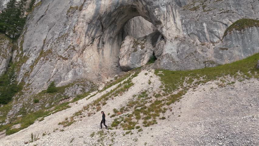 Aerial adult woman hiking Romanian Carpathian National Nature Park wild untouched nature mountain rocks. Travel exploring Romania nature outdoor