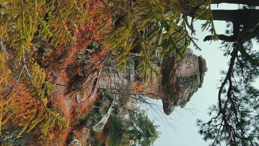 Stone City in autumn. Bright foliage and autumn landscape. The natural landscape is a rock formation in Central Russia, the Urals. A natural monument. Ancient rocky folding in the Ural Mountains. 4K