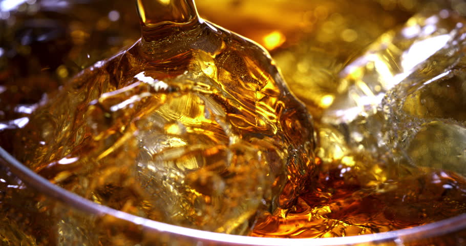 Super slow motion macro of old malt bourbon whiskey is poured in cocktail with ice cubes in transparent glass is being mixed by bartender in bar or club. Royalty-Free Stock Footage #3412991429