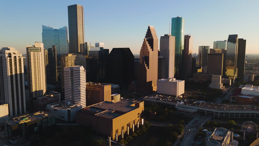 Aerial view around the sunlit skyline of Houston, dramatic sunset in Texas, USA