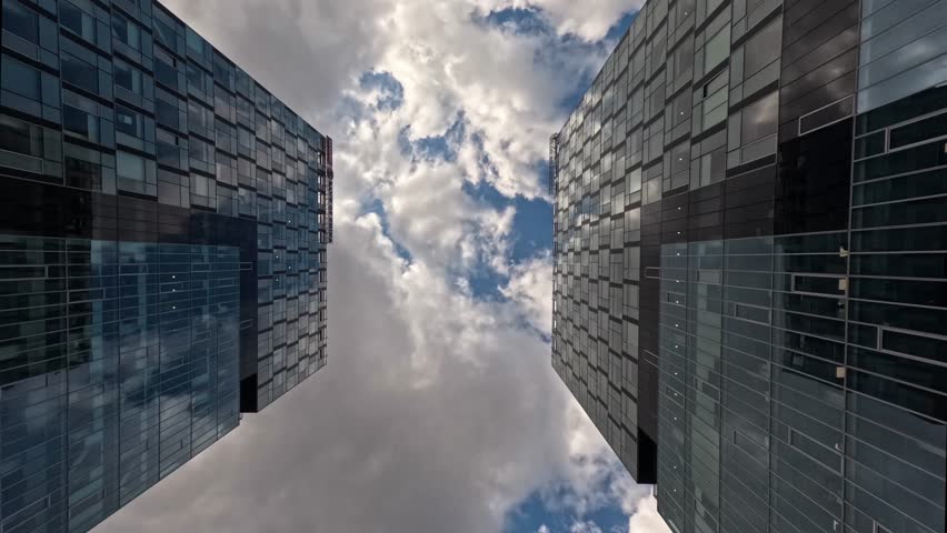 Time-lapse of skyscraper buildings in business district, Bucharest city. Clouds on sunny day sky. Low angle view. Romania financial skyline modern architecture concept Royalty-Free Stock Footage #3413039333