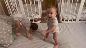 group of babies jumping on bed playing around. happy family kid dream concept. baby twins in the bedroom are freaking out jumping laughing. kids jumping and playing indoors lifestyle - Powered by Shutterstock - Get 15% off with code: PIKWIZARD15