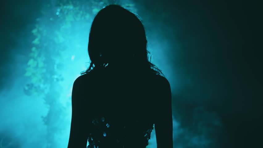 dark silhouette fantasy woman goes to bright magical divine blue moon light ray in black night garden glow, fog portal arch flowers. Mystery lady Gothic Girl princess in smoke. vampire back rear view