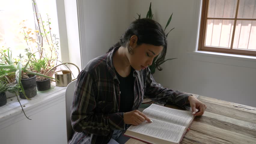 Puerto Rican girl studying bible reading scripture at desk at home Royalty-Free Stock Footage #3413133879