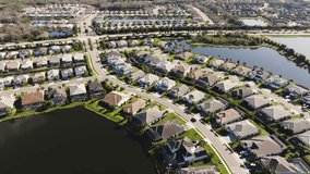 Aerial of a sunny suburban neighborhood in tropical climate flying over hundreds of homes - Powered by Shutterstock - Get 15% off with code: PIKWIZARD15