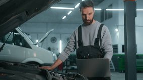 Caucasian man mechanic working in car service workshop fixing engine using laptop electronic diagnostics test repair vehicle automobile with computer technology buying online in auto shop warehouse - Powered by Shutterstock - Get 15% off with code: PIKWIZARD15