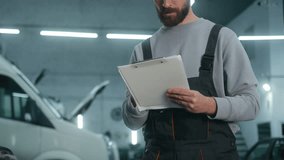 Caucasian man mechanic writing form car fixing in auto service garage maintenance work professional male technician automobile engineer write checklist auto repair diagnostics check motorcar condition - Powered by Shutterstock - Get 15% off with code: PIKWIZARD15