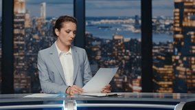 Serious anchorwoman talking news at evening studio closeup. Female presenter broadcasting live tv program holding script papers. Focused confident lady reporting newscast at television cable channel  - Powered by Shutterstock - Get 15% off with code: PIKWIZARD15
