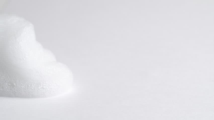 Hair foam mousse or soap suds, macro. Beauty background. Close up of white cloud of hair mousse or shaving foam.