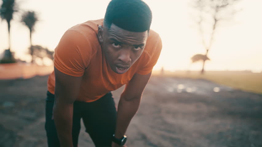 Black man, fitness and rest in sunset after exercise, outdoor cardio training or workout for recovery. Tired African male person, athlete or runner in break, breathing or sport by the city coast Royalty-Free Stock Footage #3413181141