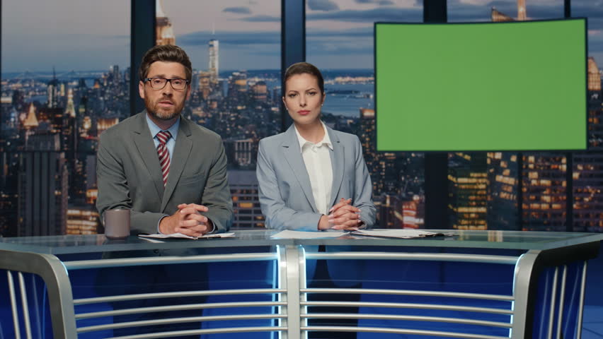 Serious presenters talking greenscreen news standing evening tv studio closeup. Couple professional anchors hosting newscast on modern channel. Two newsreaders lighting daily events in television air 