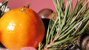 Chocolate and coconut Christmas balls - candies are spinning on the table. Tangerines. Pine needles for decoration. Video clips. Soft selective focus. Artificially created grain for the picture