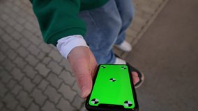 High angle view of the unknown man using smartphone green screen outside on blurred background