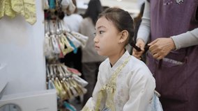 Slow-motion video of a girl wearing a Korean Hanbok doing hair and makeup in Seoul, South Korea