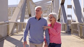 Slow motion video of an amazed mature couple of tourists walking together discovering a city