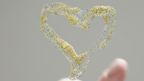 I smear golden glitter glue on the glass with my finger, creating a heart shape. View from below. - Powered by Shutterstock - Get 15% off with code: PIKWIZARD15