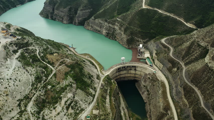 A dam to control the water level in the mountain landscape. Aerial photography of mountain rivers.