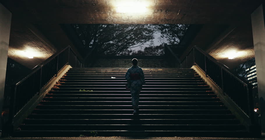 Stairs, walking and woman in the city at night for sightseeing, adventure or journey. Travel, steps and back of Japanese female person in kimono commuting in urban Tokyo town on weekend trip.