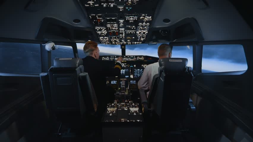 Pilots Sit in Plane Cabin Seats and Fly at Day Time Sky. View on Professional Men Using Technology of Airplane Control Panel to Flight Study. Aircraft Aviators in Scenic Cockpit with Panoramic Skyline Royalty-Free Stock Footage #3413400515