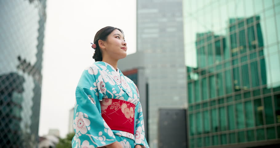 Japanese woman, happy and travel in city with kimono, view and tour with positive attitude with wellness. Person, thinking or traditional clothes by urban town buildings or journey in tokyo culture Royalty-Free Stock Footage #3413434341