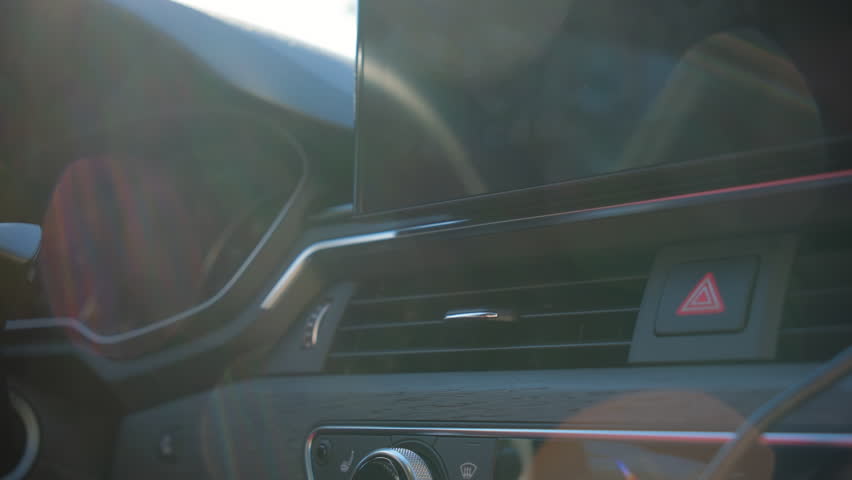 The driver's hand controls the direction of movement of ventilation and air conditioning air on car dashboard. 