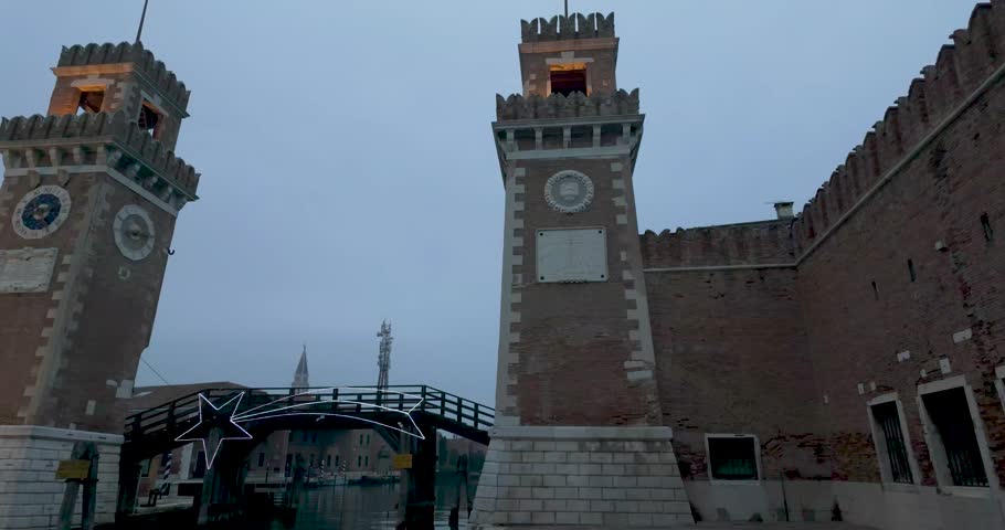 A slow pan shot of the entrance to Venice Arsenal revealing the clocktower on a night winter day Royalty-Free Stock Footage #3413629571