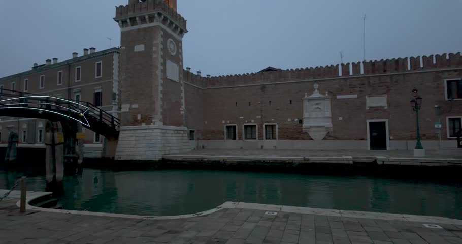 A slow pan shot of the entrance to Venice Arsenal revealing the clocktower on a night winter day Royalty-Free Stock Footage #3413634991