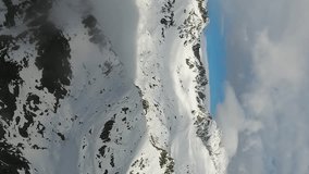 Flying over snow-capped mountains in clouds. Aerial landscape in Adamello Brenta, Italy. Vertical video - Powered by Shutterstock - Get 15% off with code: PIKWIZARD15