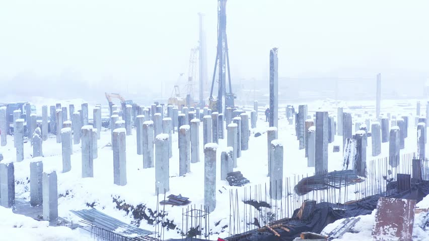 Construction site. Construction of a new residential apartment building, enterprise, warehouse, factory. Top down aerial view. Construction equipment.