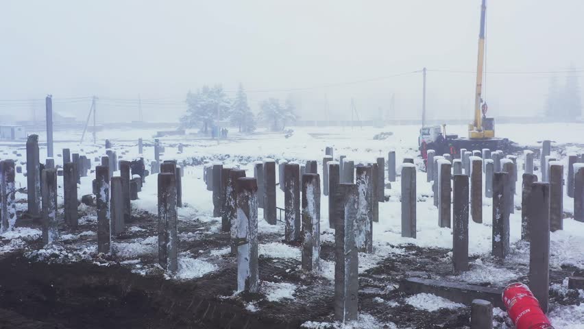 Construction site. Construction of a new residential apartment building, enterprise, warehouse, factory. Top down aerial view. Construction equipment.