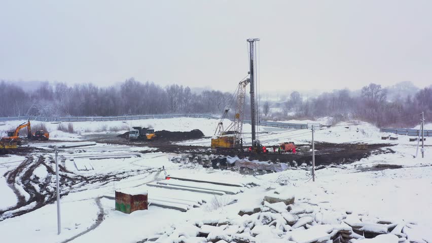 Construction site. Construction of a new residential apartment building, enterprise, warehouse, factory. Top down aerial view. Construction equipment.