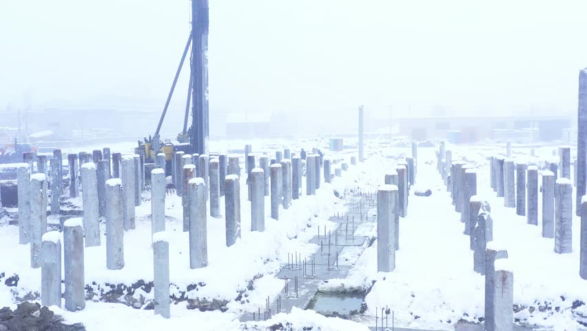 Construction site. Construction of a new residential apartment building, enterprise, warehouse, factory. Top down aerial view. Construction equipment.