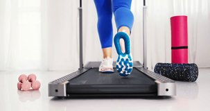 Woman training on walking treadmill at home or in gym, training, lose weight, cardio exercising, fitness, yoga, pilates video