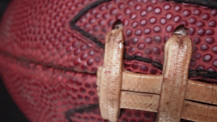 Macro laces of a football slide across the screen