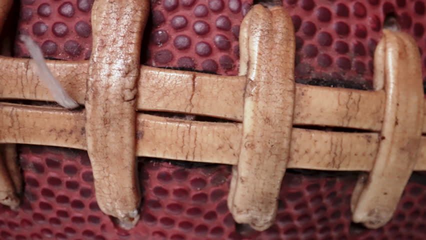 Macro laces of a football slide across the screen