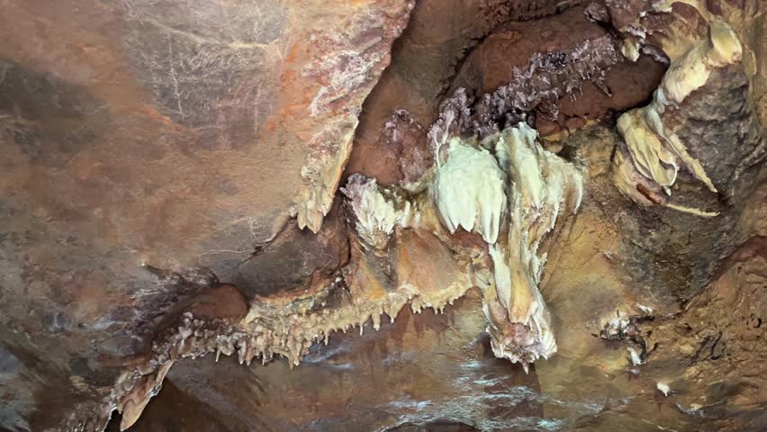 Intricate cave formations with stalactites and mineral deposits