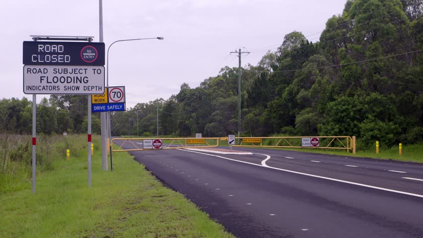 Road closure with flooding sign and flashing closed sign on Brisbane Road, Australia