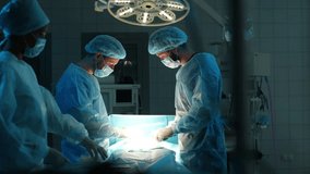 Remote tracing shot of skilled diverse team of professional doctors operating surgery in dark hospital room. Patient undergoing serious heart transplant surgery. Shooting in slow motion. - Powered by Shutterstock - Get 15% off with code: PIKWIZARD15