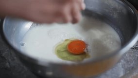 Freshly cracked egg yolk dropped into bowl of milk, filmed as closeup slow motion shot - Powered by Shutterstock - Get 15% off with code: PIKWIZARD15