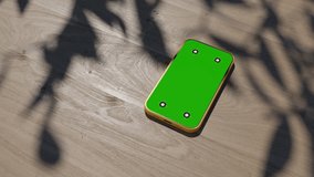 A phone lying on a table, an animation of a gadget on a wooden table. The video has a green screen and a camera motion effect
