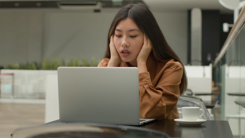 Tired sad exhausted Asian business woman bored student businesswoman difficult project work laptop computer in cafe young 20s chinese japanese korean girl freelancer has job stress problem headache Royalty-Free Stock Footage #3413966023