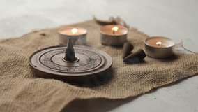 An incense cone burning and generating aromatic smoke surrounded by small candles - Powered by Shutterstock - Get 15% off with code: PIKWIZARD15