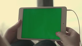 Woman hands using at tablet with green screen and scrolling pages