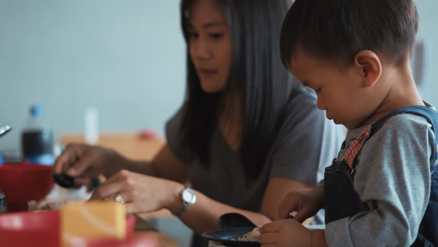 A year and 11 months old Asian baby eating food feed by his mother