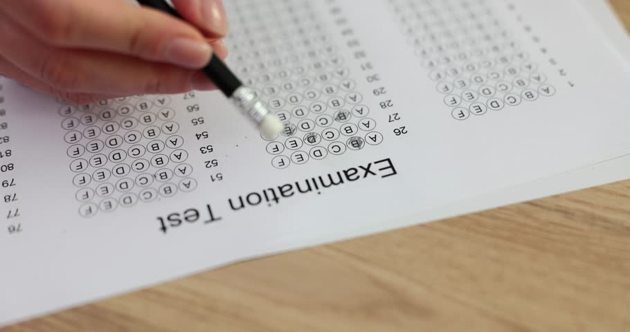 Student hand erases wrong answer on exam form with light eraser on end of pencil. Testing knowledge and taking test responsibly in educational institution Royalty-Free Stock Footage #3414209617