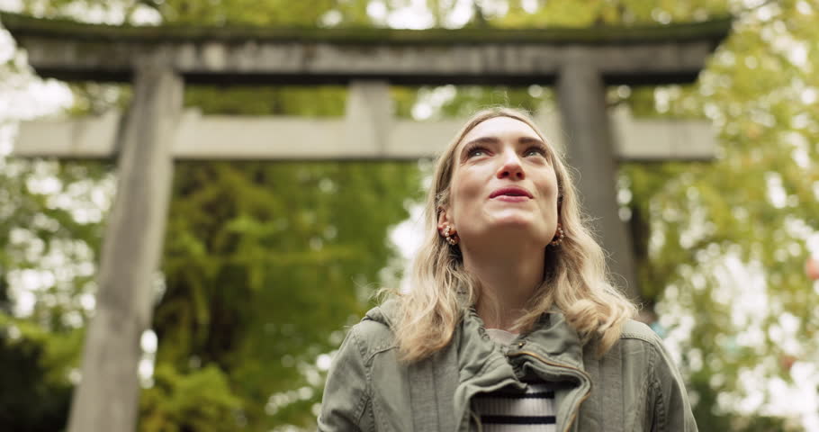 Woman, nature and torii gate in Kyoto with wow, mindfulness and travel with spiritual history. Architecture, japanese culture and shinto shrine in woods with sculpture, memorial and monument