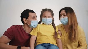 The concept of happy family. Dad Mom and Child Together at home in quarantine masks. family together communicate in video with relatives. Parents and baby, along with loved ones, talk about video call