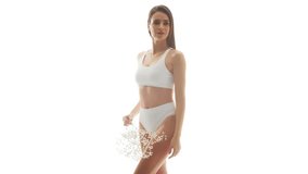 Beautiful woman in white underwear over isolated white background. Studio video of healthy young girl in swimsuit. Health and skin care, wellness, dieting and cosmetics concept.