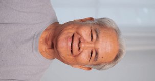 Vertical clip. Close up, portrait of older man smiling and looking at the camera.